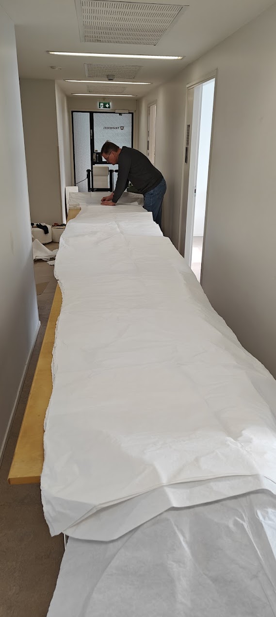 Person preparing CD profile paper samples on a long table in a hallway at the Tapio lab.